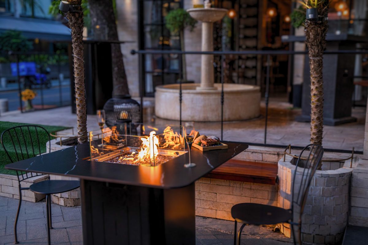 Stół BRUGGE z płonącym ogniem na tarasie restauracji